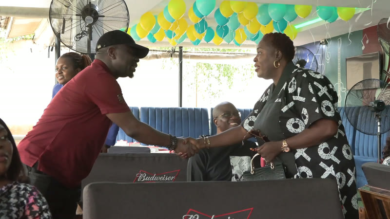 Two members shaking hands under the balloons