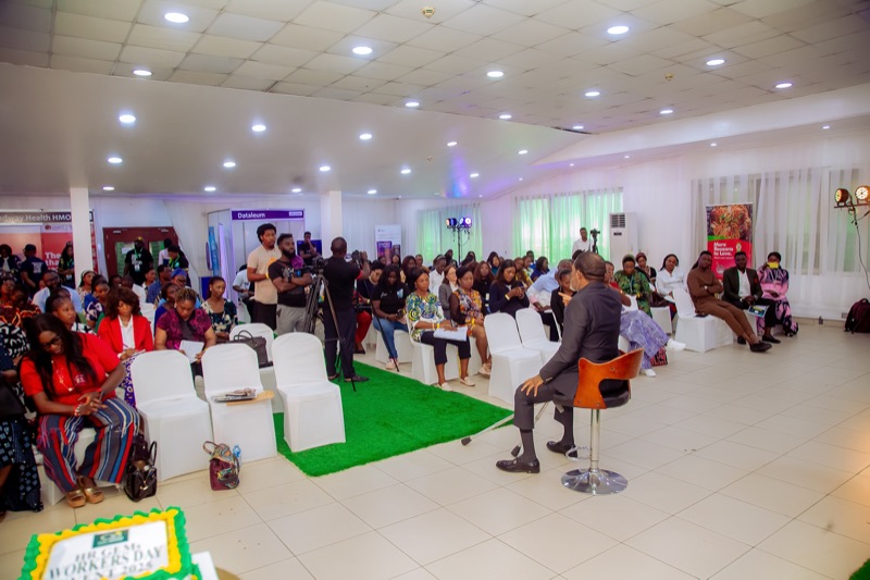 A packed hall of attendees listening to a speaker