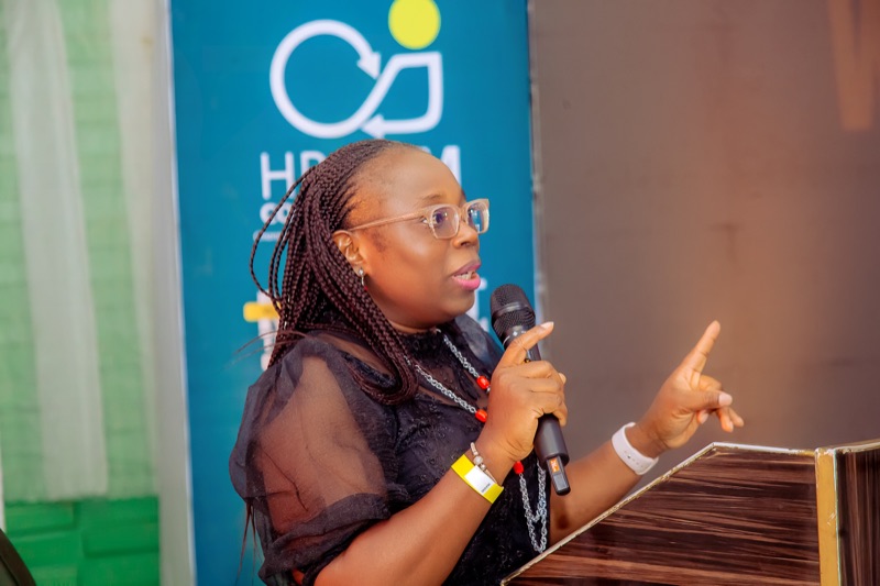 A speaker gesturing as she talks at the podium