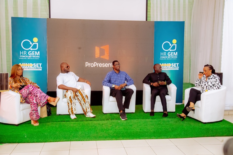 Five panellists on white chairs on the Mindset Transformation stage
