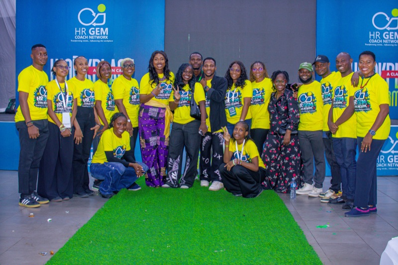 The HR GEMs team in yellow T-shirts posing on the green carpet